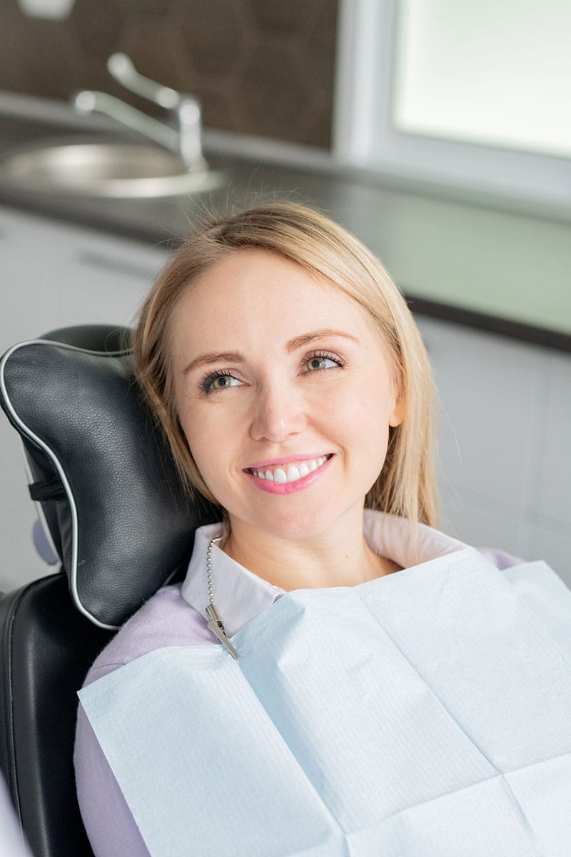 smiling female patient in dental chair