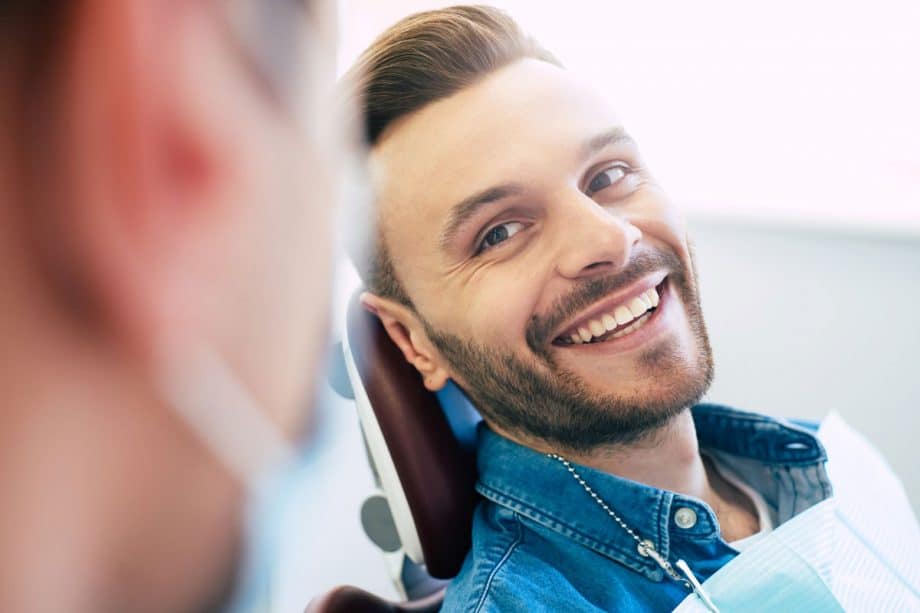 smiling male patient in dental chair