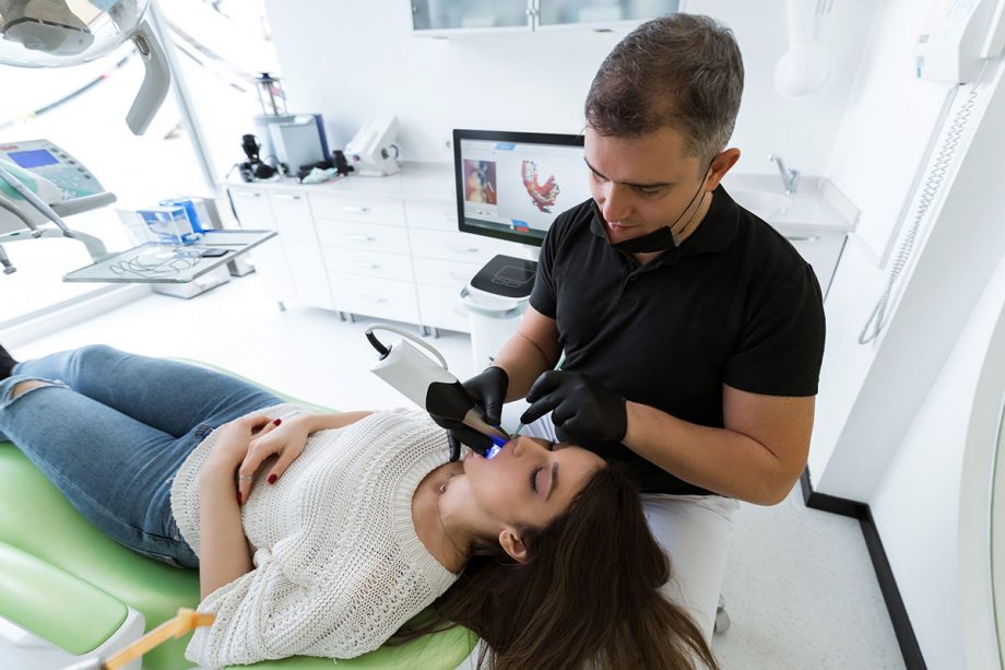 dentist using technology to examine patient's mouth