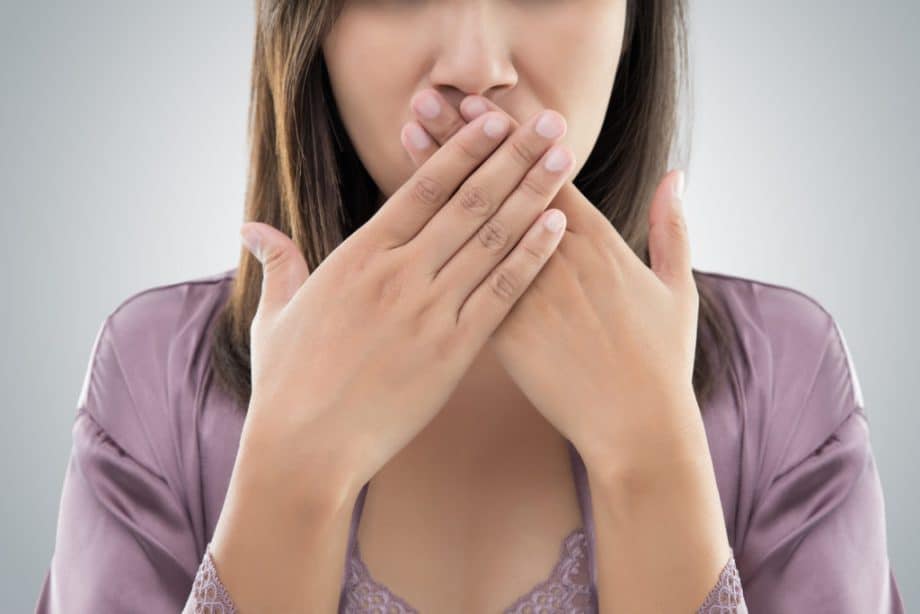 woman covering mouth with both hands