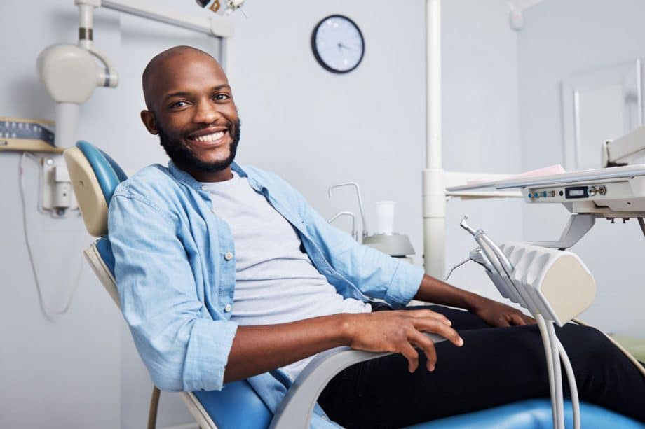 man in dental chair, smiling