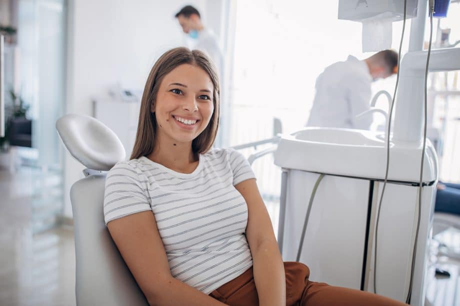 smiling woman leaning in dental exam chair