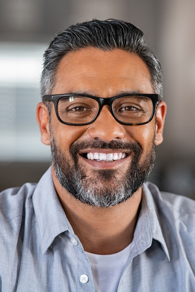 smiling man with black framed glasses