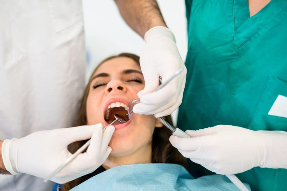 dentist examining the mouth of a female patient